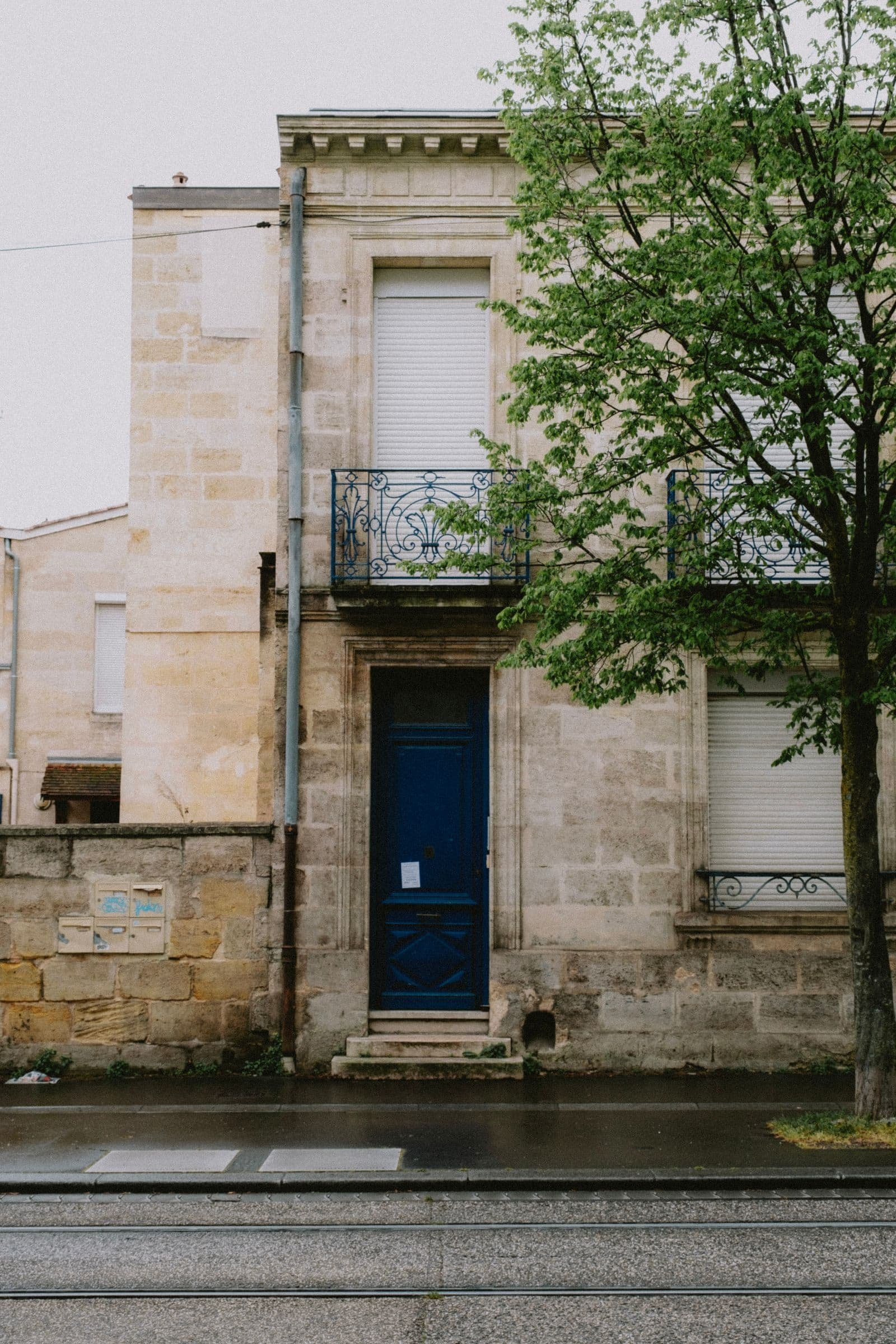Maison individuelle en pierre avec porte d'entrée et arbre attenant